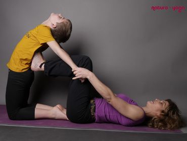 Professeur et enfant en posture de yoga 