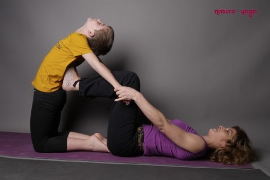Professeur et enfant en posture de yoga 
