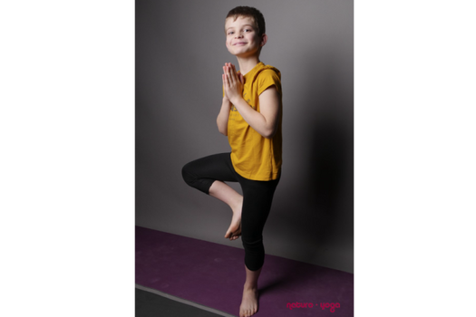 Jeune enfant en équilibre lors d'une séance de yoga